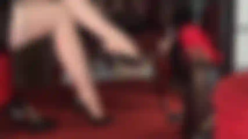 Meia-calça nude com padrão de ligas e costuras, pernas cruzadas e pés sedutores que balançam diferentes pares de sapatos clássicos.