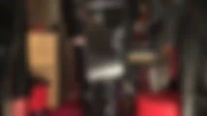 Amante fetichista de pvc brilhante, com chicote de montaria e botas acima do joelho.