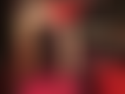 Provocação sensual e adoração ao corpo em vermelho e preto - a amante usa um vestido sexy com espartilho de couro, meia-calça nude brilhante e sapatos vermelhos brilhantes.