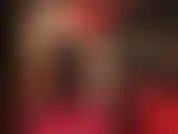 Provocação sensual e adoração ao corpo em vermelho e preto - a amante usa um vestido sexy com espartilho de couro, meia-calça nude brilhante e sapatos vermelhos brilhantes.