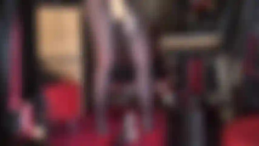 Uma deusa do cetim, de meia-calça com um pau grande - blusa de cetim dourado brilhante e luvas combinando que acariciam um pau grande e lindo de cinta-liga, pernas de náilon sedosas e saltos vermelhos sensuais.