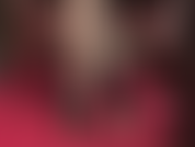 Prostrada aos pés da senhora, vestida com meias de seda transparentes e brilhantes, com costuras e sapatos de verniz brilhantes.