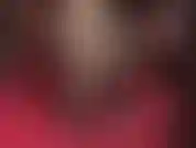 Prostrada aos pés da senhora, vestida com meias de seda transparentes e brilhantes, com costuras e sapatos de verniz brilhantes.