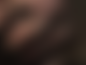 Rosto em close, batom vermelho brilhante, luvas pretas de cetim.