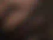 Rosto em close, batom vermelho brilhante, luvas pretas de cetim.