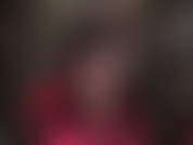 Com pernas cruzadas, meia-calça preta transparente e sapatos de salto alto de aço pendurados.