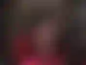 Com pernas cruzadas, meia-calça preta transparente e sapatos de salto alto de aço pendurados.