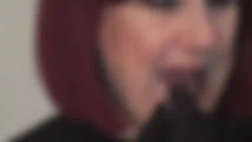 Lábios vermelhos brilhantes fazem você cair de joelhos - a amante aplica batom vermelho e provoca com sua boca sedutora, lambendo lentamente os lábios.