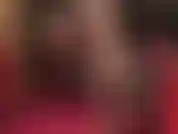 Baixinha e provocante, com sapatos de verniz brilhantes e meias pretas sobre meia-calça nude.