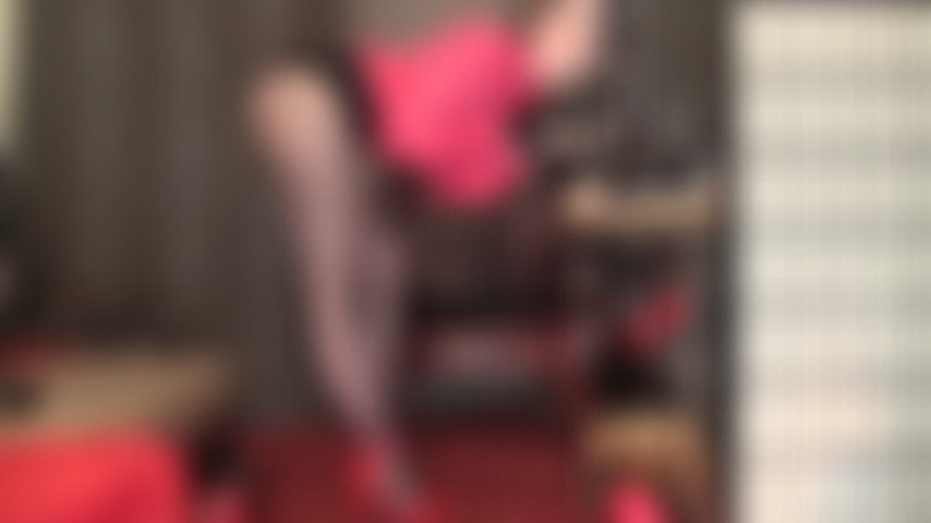 A senhora passa as mãos enluvadas sobre um pau grande enquanto exibe suas pernas incríveis em meia-calça preta transparente e sapatos de salto alto vermelhos de tiras finas.