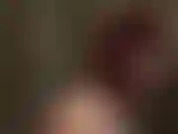 Uma amante de látex feroz e vermelha com chicote de montaria.