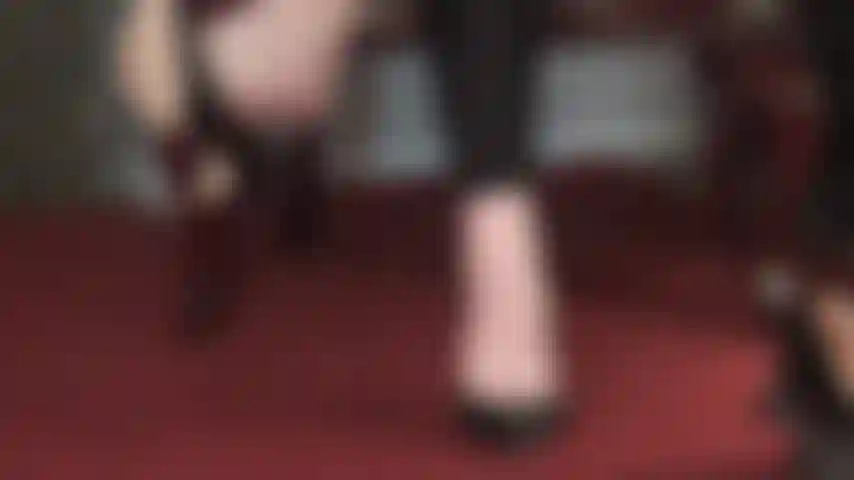 Balançando calmamente os pés descalços - dedos fofos aparecendo por trás dos sapatos de couro balançando o sapato habilmente.