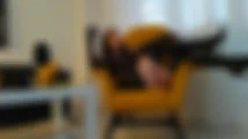 Fumando um charuto com luvas de couro, botas e minissaia.