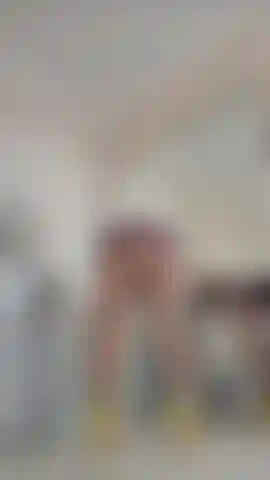 Vestido de látex bem curto, meia-calça e seios provocantes.