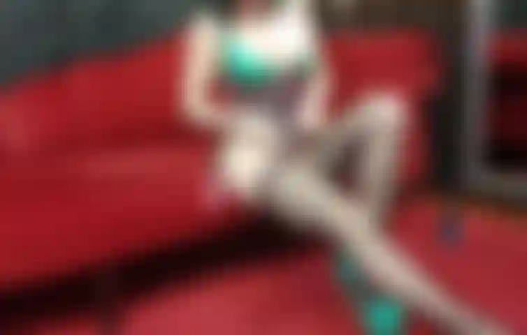 Provocando em corselete de látex e meias arrastão, exibindo buceta.