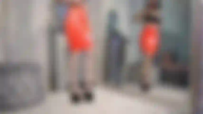 Saia de látex oleada, peitos e buceta à mostra.