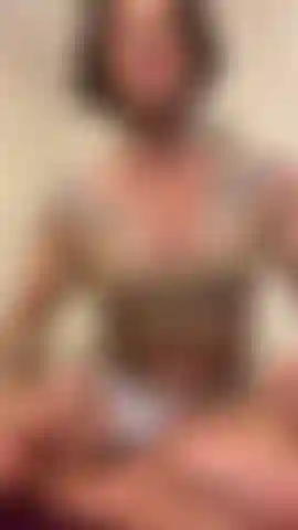 Exibindo músculos em uma blusa bege.