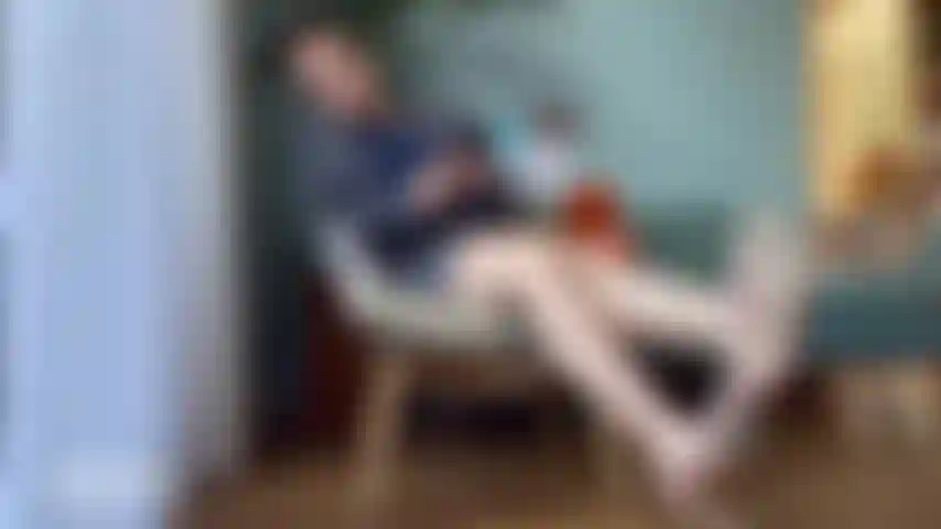 Mulher de negócios relaxada e distraída com salto alto balançando.