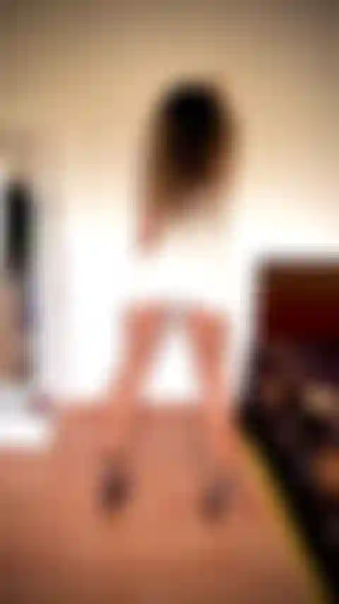 Panturrilhas e isquiotibiais incríveis flexionando, usando um vestido branco curto e justo, curvado na parede, sem calcinha.