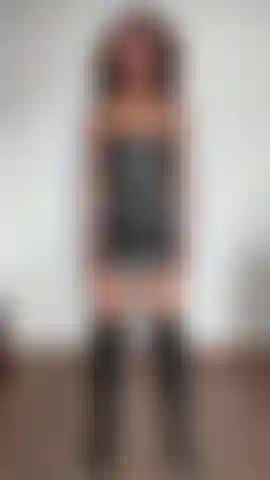 Tenho bíceps flexionados e uso um vestido de couro preto e botas.