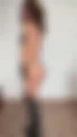 Com uma tanga preta entre as nádegas, costas sensuais, botas e luvas.