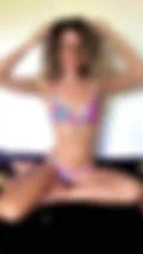 Posando de biquíni na minha cama exibindo meu abdômen.