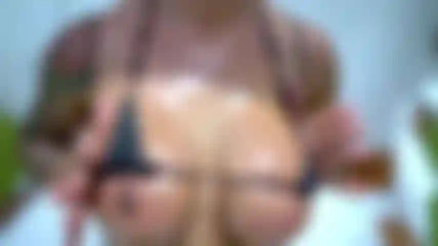 Provocação de biquíni com spray de óleo ao ar livre em dias quentes de verão.