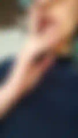 Uma latina sexy fumando, lambendo os lábios e soprando círculos de fumaça, enviando beijos.